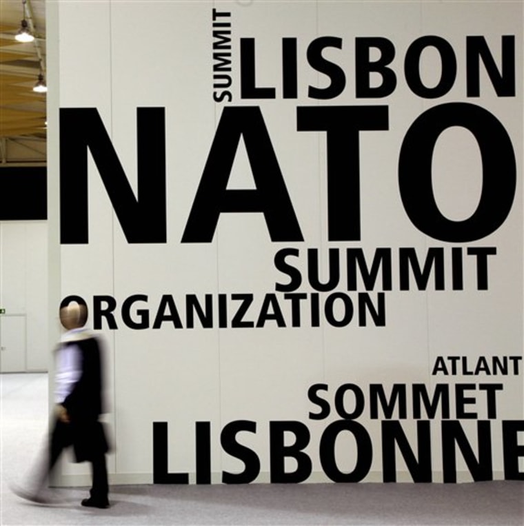 A man walks by a logo printed on a wall inside the NATO summit venue in Lisbon, Portugal on Thursday. Heads of State of NATO member countries gather for a two day summit beginning on Friday, and will discuss such topics as Afghanistan and missile defense.